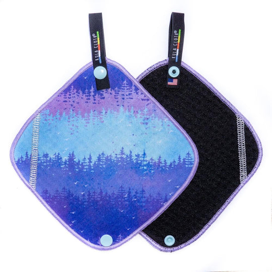 Two reusable pads with a blue to purple nature-themed design on a white background