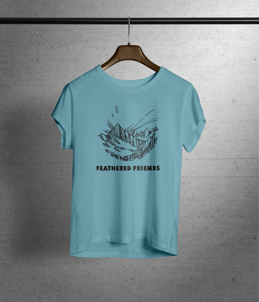 Studio image of Feathered Friends Women's Mountain T-Shirt hanging on coat hanger blue sage color